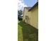 The side yard features a well-maintained lawn with mature trees and minimal landscaping with a small, utilitarian structure at 7418 Riverbank Dr, New Port Richey, FL 34655