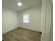 Empty bedroom featuring wood-look floors, bright natural light from a window, and white walls at 22011 Catherine Ave, Port Charlotte, FL 33952
