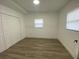 Spacious bedroom with wood-look flooring, closet, and bright natural light from two windows at 22011 Catherine Ave, Port Charlotte, FL 33952