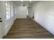 Bright living room featuring wood-look flooring, white walls, and two large windows at 22011 Catherine Ave, Port Charlotte, FL 33952
