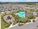 Aerial view showcasing the community pool and playground surrounded by lush greenery at 5289 Fiddle Fig Ave, Wimauma, FL 33598