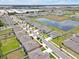 A residential neighborhood with well-maintained lawns and sidewalks lining the streets next to a tranquil pond at 5289 Fiddle Fig Ave, Wimauma, FL 33598