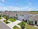 Inviting aerial shot of a home near a pond in a lovely community with manicured lawns and mature trees at 5289 Fiddle Fig Ave, Wimauma, FL 33598