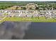 Backyards lining a large pond, showcasing well-maintained lawns and fence lines at 5289 Fiddle Fig Ave, Wimauma, FL 33598