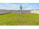 Spacious backyard with lush green grass and a white fence, perfect for outdoor activities and relaxation at 5289 Fiddle Fig Ave, Wimauma, FL 33598