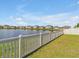 Scenic backyard view with a tranquil pond and well-maintained lawn, perfect for outdoor enjoyment at 5289 Fiddle Fig Ave, Wimauma, FL 33598