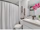 Well-lit bathroom features a shower with curtain, stylish decor, and a modern sink with sleek faucet at 5289 Fiddle Fig Ave, Wimauma, FL 33598