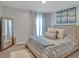 Comfortable bedroom with soft hues, a full-length mirror and natural light at 5289 Fiddle Fig Ave, Wimauma, FL 33598