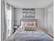 Cozy bedroom featuring a comfortable bed with decorative pillows, stylish artwork, and bright natural light at 5289 Fiddle Fig Ave, Wimauma, FL 33598