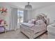 Charming ' bedroom with a fancy light fixture, comfortable bed, playful decor, and natural light at 5289 Fiddle Fig Ave, Wimauma, FL 33598
