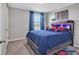 The bedroom boasts a built-in headboard with decor and blue curtains at 5289 Fiddle Fig Ave, Wimauma, FL 33598