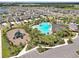An aerial view of the community pool, playground, lush landscaping, and ample parking at 5289 Fiddle Fig Ave, Wimauma, FL 33598