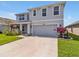 Charming two-story home featuring a spacious driveway and beautifully landscaped front yard at 5289 Fiddle Fig Ave, Wimauma, FL 33598