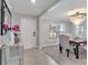 Bright foyer with decorative cabinet, view of dining room featuring a chandelier and stylish seating at 5289 Fiddle Fig Ave, Wimauma, FL 33598
