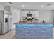 Modern kitchen featuring a stone-clad island with blue accent lighting and stainless steel appliances at 5289 Fiddle Fig Ave, Wimauma, FL 33598
