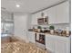Modern kitchen featuring white cabinets and an island with marbled countertops at 5289 Fiddle Fig Ave, Wimauma, FL 33598