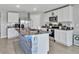 Modern kitchen with stainless steel appliances, granite countertops, white cabinets, and a stylish center island at 5289 Fiddle Fig Ave, Wimauma, FL 33598
