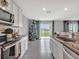 Open concept kitchen with stainless appliances, granite countertops, and view to backyard at 5289 Fiddle Fig Ave, Wimauma, FL 33598