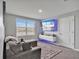 Contemporary living room with a plush gray sofa, entertainment center, and a window with a view at 5289 Fiddle Fig Ave, Wimauma, FL 33598