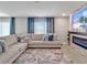 Spacious living room with large sectional sofa and modern fireplace with blue accent lighting at 5289 Fiddle Fig Ave, Wimauma, FL 33598