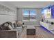 Cozy living room with comfortable gray sofa, ottoman, large window, and mounted TV at 5289 Fiddle Fig Ave, Wimauma, FL 33598