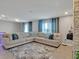 Spacious living room featuring a large sectional sofa and neutral decor at 5289 Fiddle Fig Ave, Wimauma, FL 33598