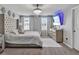 This main bedroom features a crystal chandelier, TV, and lots of natural light at 5289 Fiddle Fig Ave, Wimauma, FL 33598
