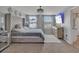 Stylish main bedroom with large upholstered headboard, decorative chandelier and neutral tones at 5289 Fiddle Fig Ave, Wimauma, FL 33598