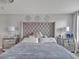 Elegant main bedroom features tufted headboard, mirrored nightstands, and soft lighting at 5289 Fiddle Fig Ave, Wimauma, FL 33598