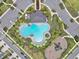A modern community pool area features a uniquely shaped pool, playground, ample parking, and well-maintained landscaping at 5289 Fiddle Fig Ave, Wimauma, FL 33598