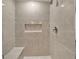 This elegant shower is tiled with a built-in bench and shelf at 5289 Fiddle Fig Ave, Wimauma, FL 33598