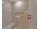 Neutral toned shower with tiled walls, seating, and convenient inset shelf at 5289 Fiddle Fig Ave, Wimauma, FL 33598