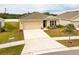 Well-kept single-story home with a spacious driveway, an attached two-car garage, and vibrant landscaping at 1324 Ocean Spray Dr, Ruskin, FL 33570