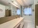 Bathroom featuring a large vanity, neutral tile, and natural light at 1790 Pomelo Dr, Venice, FL 34293