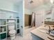 Bright bathroom with tiled shower, built-in shelving, and a white tiled floor at 1790 Pomelo Dr, Venice, FL 34293