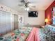 Cozy bedroom featuring a ceiling fan, TV, and tropical-themed decor and furnishings at 1790 Pomelo Dr, Venice, FL 34293