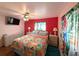 Bright bedroom with tropical bedding, ceiling fan, mounted tv, and hardwood floors at 1790 Pomelo Dr, Venice, FL 34293