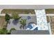 Aerial view of the front yard showcasing a custom driveway, rock garden, unique landscaping, and healthy green trees at 1790 Pomelo Dr, Venice, FL 34293