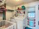 Bright laundry room featuring a modern washer and dryer, with storage shelves and a colorful door at 1790 Pomelo Dr, Venice, FL 34293