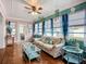 Bright sunroom with comfortable seating, windows, and access to the front yard at 1790 Pomelo Dr, Venice, FL 34293