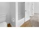 Bathroom area featuring a toilet and bathtub with tile walls, and modern fixtures at 5154 51St W Ln, Bradenton, FL 34210
