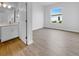 Bright bedroom with modern wood-look flooring and bathroom access featuring a white vanity and neutral countertops at 5154 51St W Ln, Bradenton, FL 34210