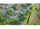 Aerial view showcasing homes with backyard pools and lush greenery within a residential community at 7490 Locust Ne St, St Petersburg, FL 33702