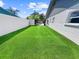 Manicured backyard showcasing lush, green artificial turf between the house and a privacy fence at 7490 Locust Ne St, St Petersburg, FL 33702