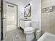 Bathroom featuring a decorative mirror, pedestal sink, and a bathtub with a tiled wall at 7490 Locust Ne St, St Petersburg, FL 33702