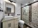 Modern bathroom with a stylish sink, granite countertop and a glass-enclosed shower featuring unique tile accents at 7490 Locust Ne St, St Petersburg, FL 33702