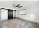 Bedroom showcasing a ceiling fan, a rustic barn door, and modern flooring at 7490 Locust Ne St, St Petersburg, FL 33702