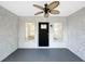 A covered front porch features a ceiling fan, exterior lighting, and a black door flanked by windows at 7490 Locust Ne St, St Petersburg, FL 33702