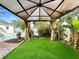 The backyard features a gazebo with a green artificial turf floor and privacy curtains at 7490 Locust Ne St, St Petersburg, FL 33702