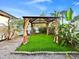 Gazebo with artificial turf and privacy curtains in a landscaped backyard near the swimming pool at 7490 Locust Ne St, St Petersburg, FL 33702